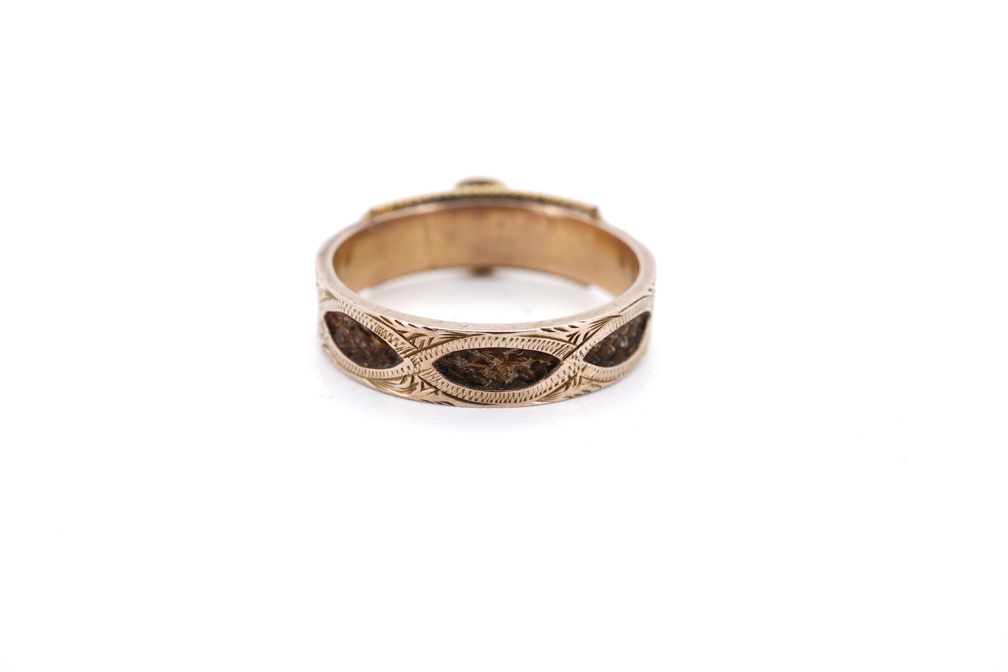 A George V 9ct gold, black enamel and seed pearl set mourning ring, the shank with panels of plaited hair, size O, gross weight 2.5 grams.